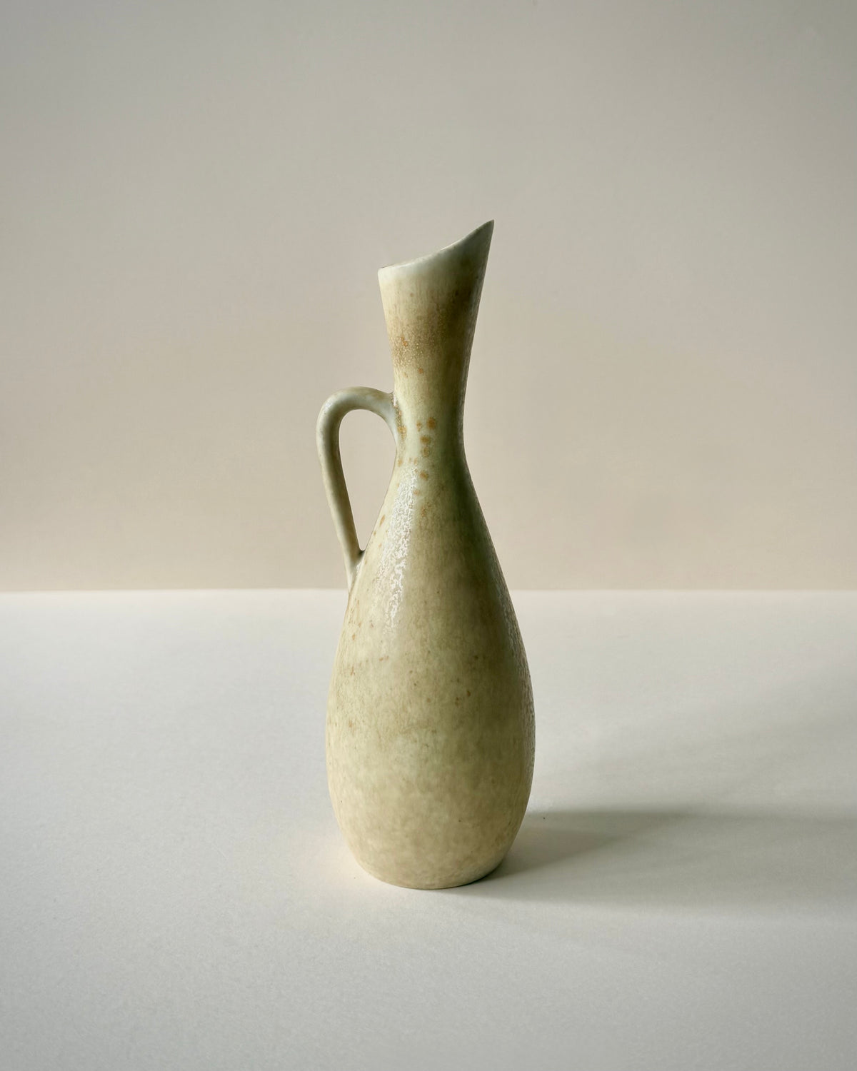 Rörstrand SYE stoneware vase by Carl-Harry Stålhane, front view with loop handle and mottled green-cream glaze