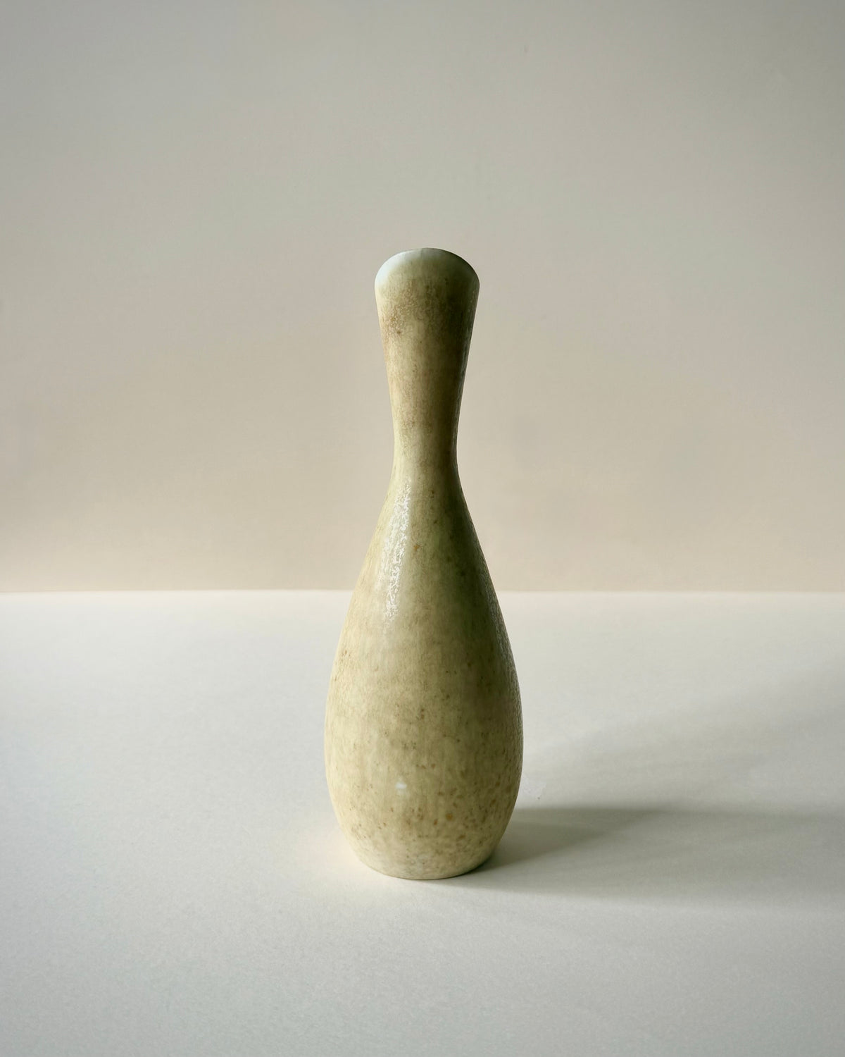 Close-up of the Rörstrand SYE vase neck, asymmetrical flared rim and handle, showing the mottled glaze with ochre-brown speckles