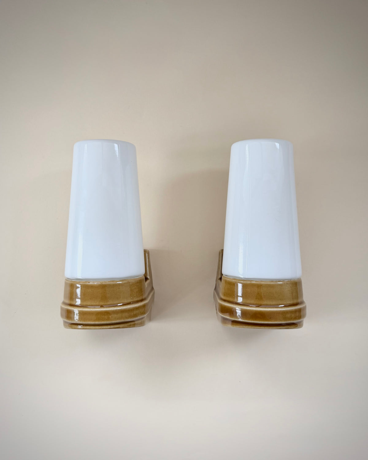 Pair of Ifö Model 6080 Bernadotte wall lamps with caramel-brown ceramic bases and white opal glass shades.