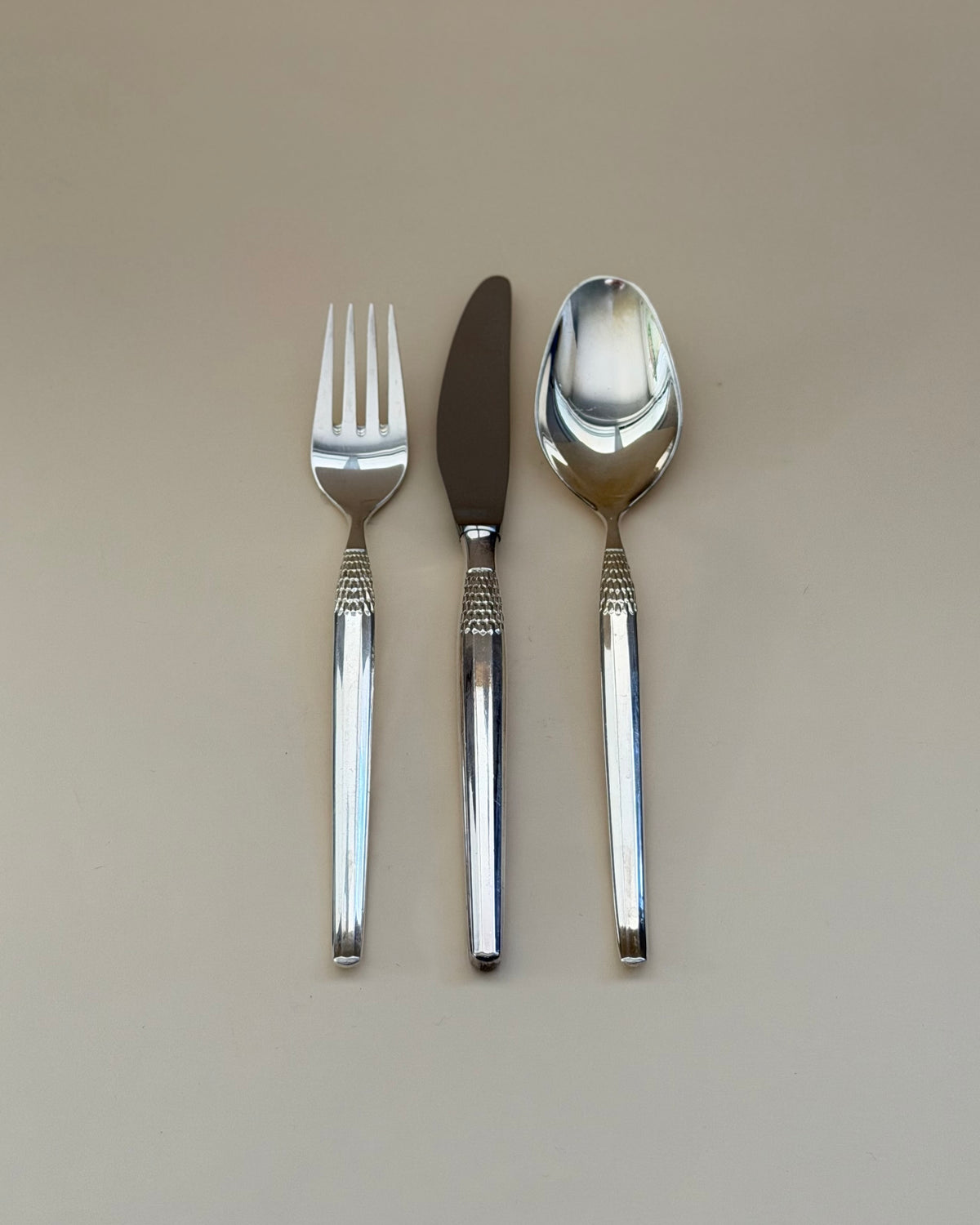Eight GAB Cheri silver-plated table knives arranged in a row, showing their textured handles.