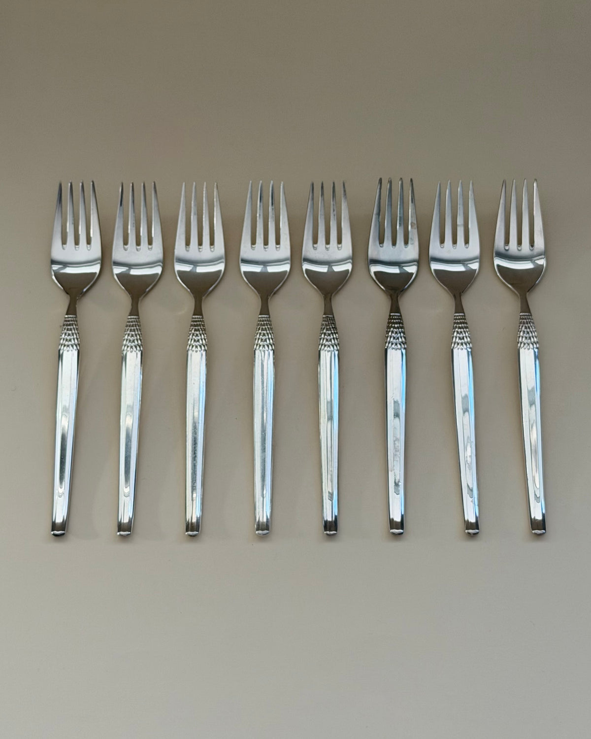 A GAB Cheri table fork, knife and spoon showing the polished surfaces and textured handle detail.