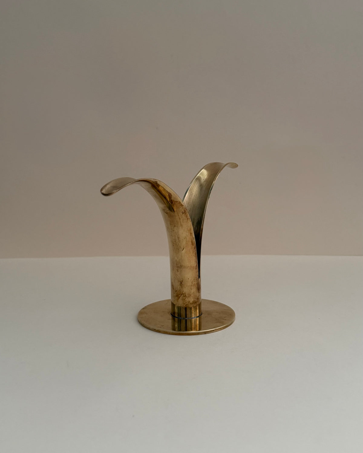 Overhead view of the two curved brass wings and central candle opening of the Ystad Metall Liljan candlestick.