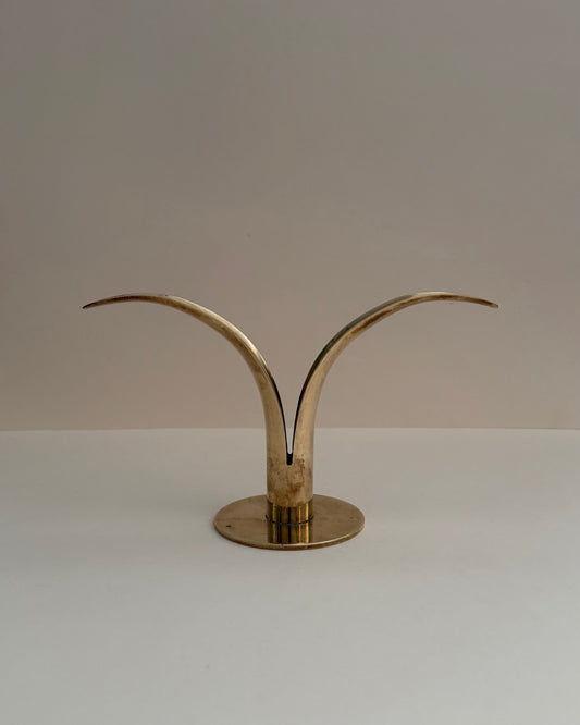 Ystad Metall Liljan solid brass candlestick, front view with two curved lily-like wings and circular base.