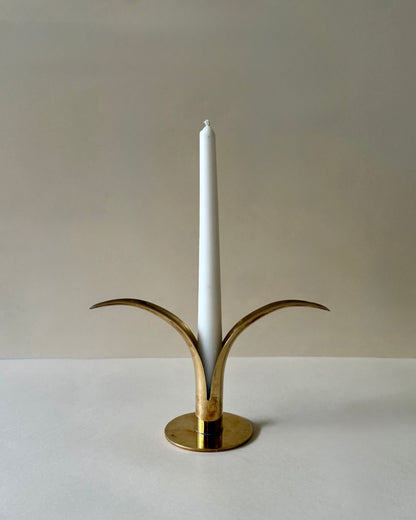 Ystad Metall Liljan brass candlestick holding a white taper candle.